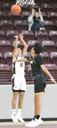 FIRING THE THREE -Littlefield junior guard, Jaron Cabello (30), buries a three from the right wing for the Wildcats, over the outstretched arm of an Andrews defender, during the first half of their home game against the Mustangs on Monday. The Wildcats won the contest, 61-35, at Wildcat Gym. (Staff Photo by Derek Lopez)