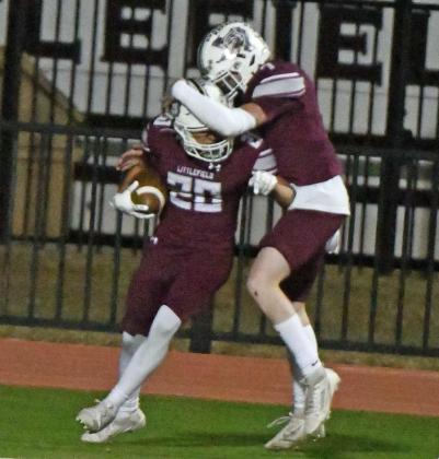 Littlefield senior, Brandon Marines (20), and junior linebacker, Jacob Silvas (7), celebrate a fumble return for a touchdown by Marines, during the fourth quarter of their 3A Area Championship victory over Crane on Friday in Lamesa. (Staff Photo by Derek Lopez)