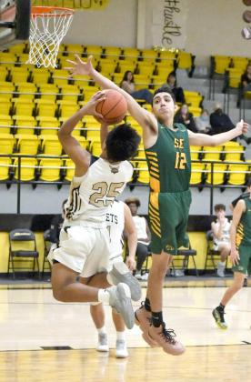 ALTERING THE SHOT— Springlake-Earth guard, Kaden Castillo (12), leaps up an alters the shot of Sudan’s Sal Juarez on the left wing, during the second half of the Wolverines’ road win against the Hornets on Saturday. (Staff Photo by Derek Lopez)