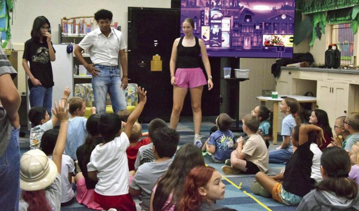 During the Lamb County library’s summer reading program on June 24, Rhealee Golden and Jordan Randle helped to entertain kids. (Photo by Leon Szaniszlo)