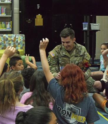 SSG Eric Comes with the United States Army, talks to kids while handing out flags at the Lamb County library’s summer reading program on June 24. (Photo by Leon Szaniszlo)