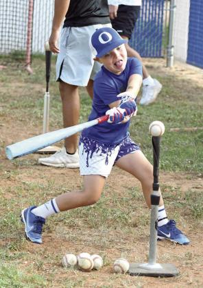 A camper during the morning session of the Olton Youth Baseball Camp gets some cuts in off of the tee, during a hitting drill last Thursday. (Staff Photo by Derek Lopez)