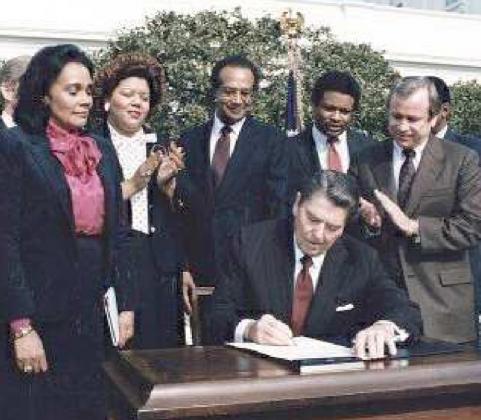 PRESIDENT REGAN SIGNING HOLIDAY INTO OFFICIAL HOLIDAY IN NOVEMBER OF 1983