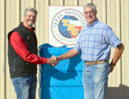 TEXAS PRODUCERS COOP in Sudan receives the first cotton bale for 2022 from producer Eric Vaughan. Vaughan’s cotton, phytogen 210, was planted May 6th, harvested Oct. 20th, and weighed 499 pounds. Guyle Roberson, CEO of the Texas Producers Coop in Sudan, shakes Vaughan’s hand and congratulates him on his first bale of cotton for the 2022 season. (Staff Photo by Samantha Pontius)