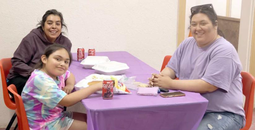 Blayke Gonzales, Rhonda Reyna-Rosemond wisely chose to eat inside the Community Center during Amherst Hamburger Fundraiser sponsored by the Amherst Chamber of Commerce. (Photo by Ann Reagan)
