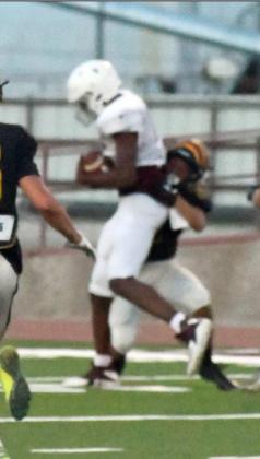 YARDS AFTER CATCH – Littlefield senior, Tyree Jones, catches a ball down field and drags a Snyder defender several more yards before being brought down, during the Wildcats’ lone scrimmage last Thursday at Wildcat Stadium. (Staff Photo by Derek Lopez)