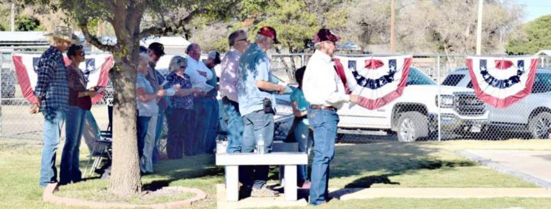 ATTENDEES of the Lamb County Veterans Memorial Service that has held on Sunday, Nov. 7, stand for the National Anthem. (Photo by Ann Reagan)