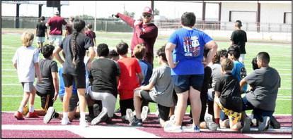 Littlefield Offensive Coordinator, Logan Mitchell, gives out directions to a group of campers, during day one of the Wildcat Youth Football Camp on Monday. (Staff Photo by Derek Lopez)