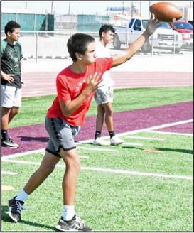 Littleifled Offensive Coordinator, Logan Mitchell, works on throwing drills with a group of campers, during day one of the Wildcat Youth Football Camp on Monday at Wildcat Stadium in Littlefield. (Staff Photo by Derek Lopez)