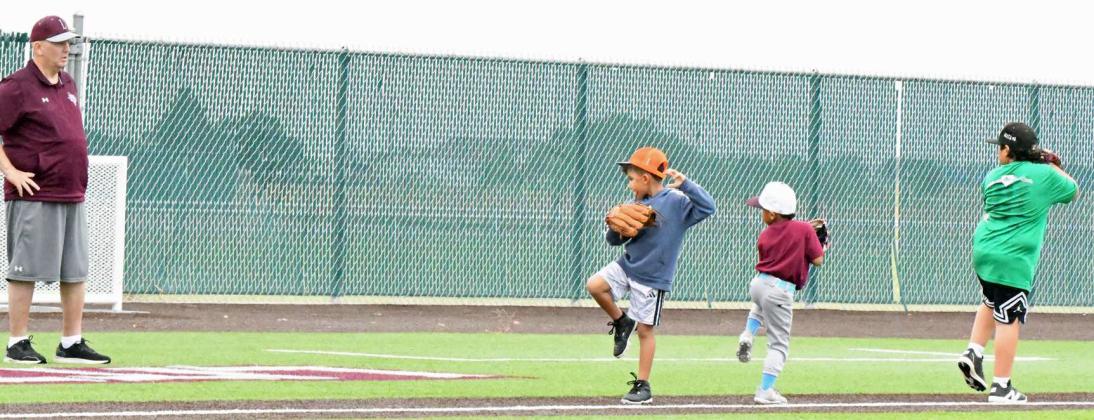 Coach Jay Ragland, works with a group of kids on pitching mechanics, during the morning session of the 2025 youth baseball camp at Wildcat Field Tuesday morning. (Staff Photo by Derek Lopez)