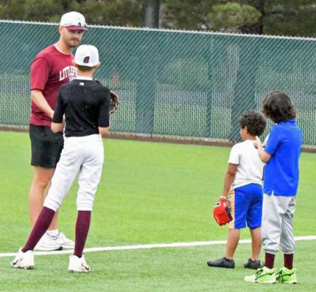 Littlefield Asst. Baseball Coach Blake Green works with a group of kids on proper outfield mechanics, during the morning session of the youth baseball camp on Tuesday morning. (Staff Photo by Derek Lopez)