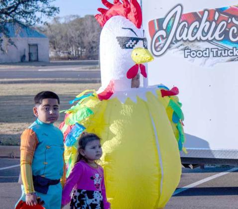 Next to Jackie’s Food Truck, children pose for a picture at the Lamb County Sheriff’s Trunk or Treat. (Staff Photo by Madison Vidales)