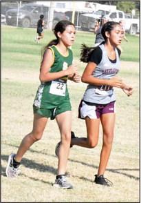 Springlake- Earth’s Amethyst Huerta and Littlefield’s Anaei Ojeda race against each other to get ahead during their race at the Littlefield Invitational last Saturday. (Staff Photo by Derek Lopez)
