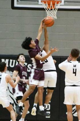 Littlefield freshman, Jayden Barrio, goes up and deliveres a block on Muleshoe’s Aaron Morales, during the first half of the Wildcats’, 8643, victory over Muleshoe on the road Tuesday night in district play. (Staff Photo by Derek Lopez)
