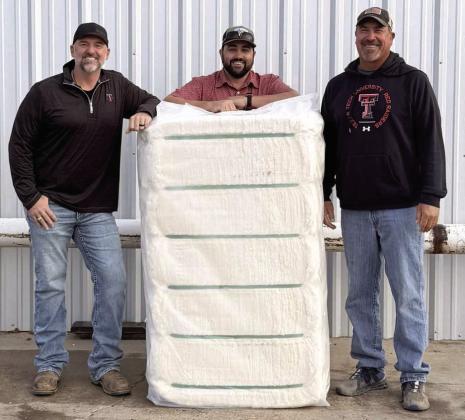 Justin Bellar, CEO, and Duncan Welch, Gin Manager with grower, Bryan Baker with the first bale of cotton to Texas Producers Cooperative gin on Oct. 16, 2025.