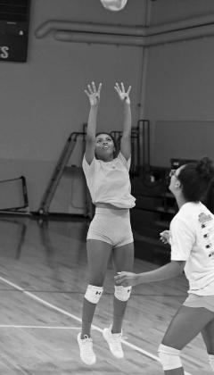 The Littlefield’s London Taylor sets the ball up in the air, looking to set up an attack during a scrimmage, during the Lady Cat’s Midnight Madness practice to open two-a-days Monday morning. (Staff Photos by Derek Lopez)