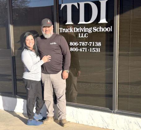 Owner and operator, Alejandro Ojeda (right) and his wife, Monica Ojeda (left) pose for a photo in front of one of the TDI Truck Driving School, LLC locations. (Submitted Photo)