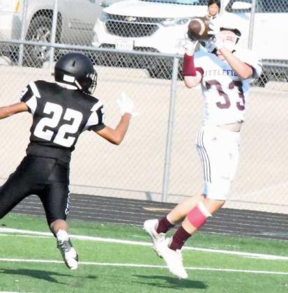 COMING BACK FOR THE BALL – Littlefield’s Brayden Redman (33) comes back for a pass from Nate Castaneda and shakes off the Muleshoe defender for a 40-yard touchdown, as the Wildcats took down Muleshoe on Thursday, 35-27, in their season-opener on the road. (Staff Photo by Derek Lopez)