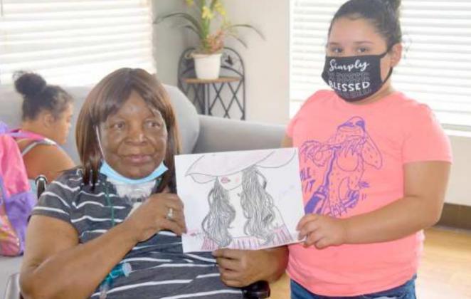 Cecelia Williams receives a gift from her friend, Aubreyella Payan who stated she prays for her every night. (Photo by Ann Reagan)