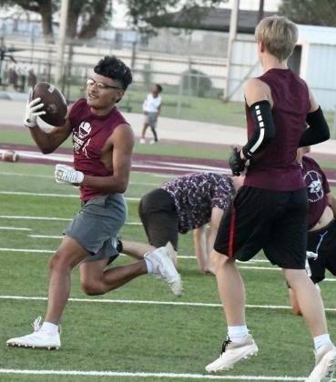 Zane Champion makes a catch and gets up field cutting through the defense during the second night of park practice at Wildcat Stadium on Tuesday. (Staff Photo by Derek Lopez)