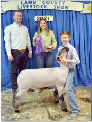GRAND CHAMPION LAMB —Kooper Edwards. Sudan, shown with Judge Kinder Harlow and special person holding belt buckle award. (Staff Photo by Joella Loworn)
