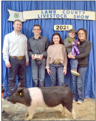 GRAND CHAMPION SWINE—Zayne Humphreys, Sudan, is shown withJudgeHarlow and family members. (Staff Photo byJoellaLoworn)