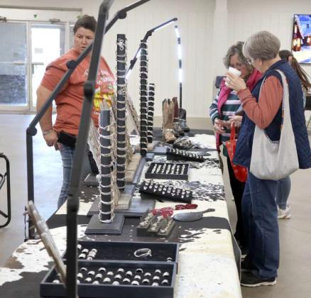 Shelby of Shelby's Wearable Silver made entirely from silver spoons searches for the right piece for her customers at the Littlefielld Trade Days held Saturday December 14, 2024. (Photo by Ann Reagan)