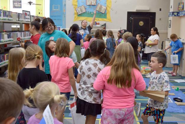 Assistant Librarian Mrs. Schroeder in the background directs the groups to their next activity during the Summer Reading Program at the Lamb County Library on Wednesday, June 7, 2023. (Photo by Ann Reagan)