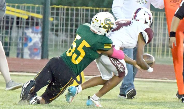 Springlake-Earth’s Nehemiah Castillo makes a tackle behind the line of scrimmage on Hart’s Hayden Hernandez, during the Longhorn’s opening drive of their district-opener Thursday in Earth. The Wolverines took the contest, 52-6. (Staff Photo by Derek Lopez)