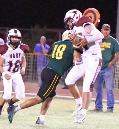 Springlake-Earth’s Timothy Tovar, lays a hit on the Hart receiver, during the Wolverine’s, 52-6, victory over the Longhorns on Thursday night. (Staff Photo by Derek Lopez)