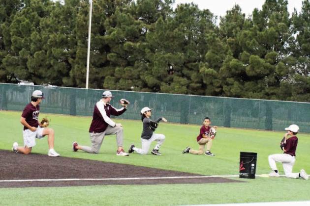 Wildcat Head Baseball Coach, Jett Hartley, demonstrates a drill for a group of campers, during the first day of baseball camp last Wednesady. (Staff Photo by Derek Lopez)