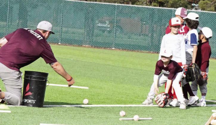 Campers work on fielding ground balls with Wildcat Head Baseball Coach, Jett Hartley, during the first day of baseball camp last Wednesady. (Staff Photo by Derek Lopez)