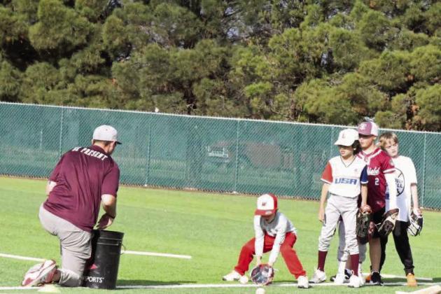 Campers work on fielding ground balls with Wildcat Head Baseball Coach, Jett Hartley, during the first day of baseball camp last Wednesady. (Staff Photo by Derek Lopez)