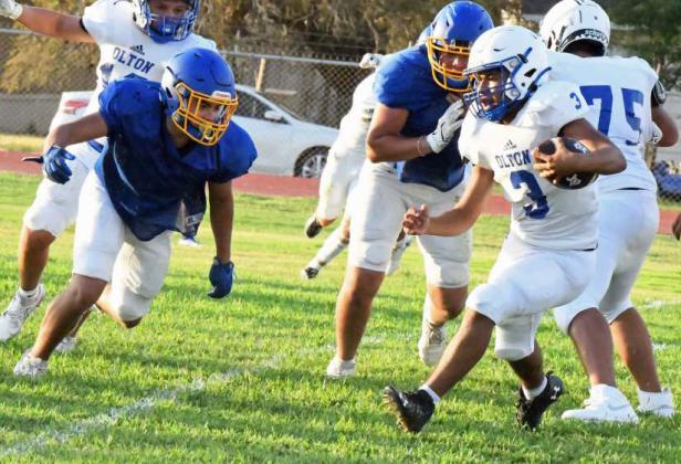 Olton’s ball carrier runs the ball up the middle dodging a defender on the goal line before taking it in for a touchdown, during the Mustangs’ scrimmage with the Owls on Thursday at Owl Stadium. (Staff Photo by Derek Lopez)