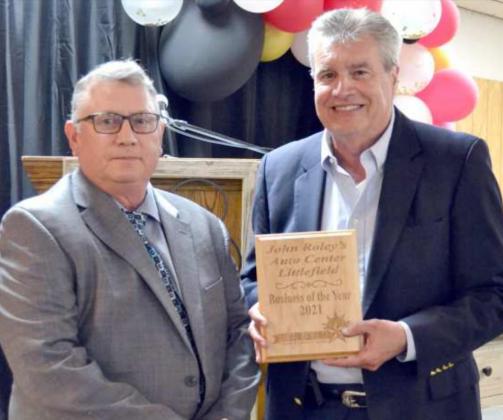 BUSINESS OF THE YEAR--John Roley holds the plaque for John Roley’s AutoCenter award as Business of the Year. Robert Watson introduced and presented the award. (Staff Photo, Joella Lovvorn)