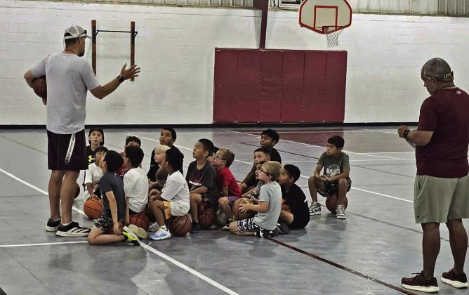 Littelfield varsity basketball coach, Nathan McKinnon, addresses the morning session of campers, before they begin the first day of basketball camp on Monday, June 8th. (Staff Photo by Derek Lopez)