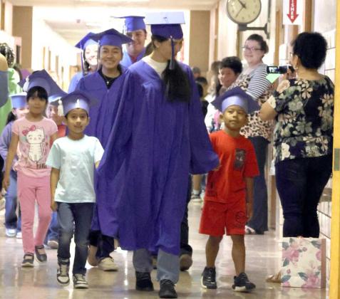 The 2024 graduates of Amherst ISD take their final Senior Walk through the school with the youngest students at the school. (Photo by Ann Reagan)