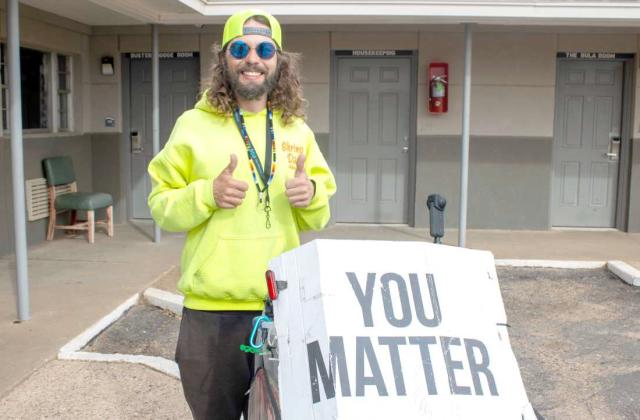 Before heading out on a 17-mile walk, mental health advocate Kyndal Ray Edwards poses next to his ‘You Matter’ sign on Jan. 28, 2025, in Littlefield, Texas. (Photo by Madison Vidales)