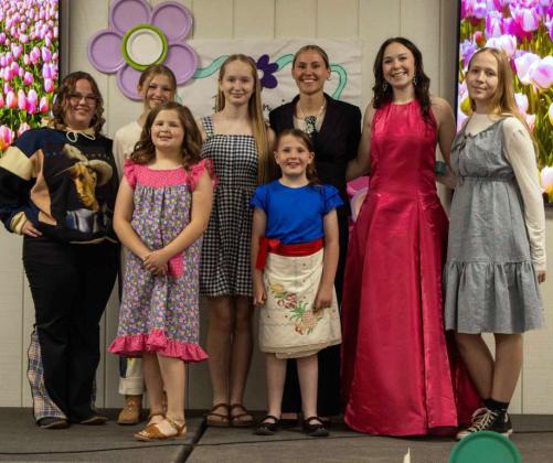 Loren Campbell, Imri Jobe, Lillian Burt, Jeri Holcomb, Claire Lostroh, Charlotte Burt, Maceyn Bellar and Frankie Campbell pose for a photo at the Lamb County 4-H Fashion Show: Fashion in Full Bloom on April 2, 2026. (Photo by Madison Vidales)