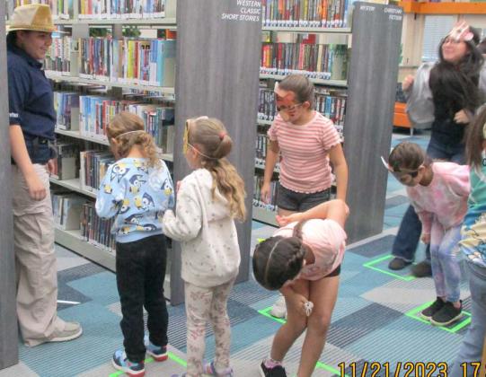 Library Volunteer, Mallory Marquez, leads kids on an activity at the Lamb County Library, during William Thompson’s Book signing for his book ‘Jungle O’s’. (Submitted Photo)