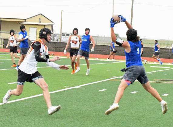 Olton’s Avery Garcia catches a pass on the near side from quarterback Raymond Ramirez, during the Mustang’s 7v7 game against the Wink Wildcats on Saturday in Sudan. (Staff Photo by Derek Lopez)
