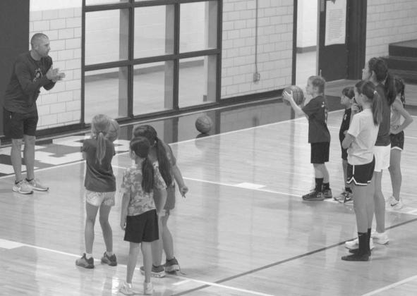 Head Coach Jay Gorman works with campers on shooting fundamentals during the Olton Fillie Basketball Camp on June 2 at Olton Gymnasium. (Photo by Leon Szaniszlo)