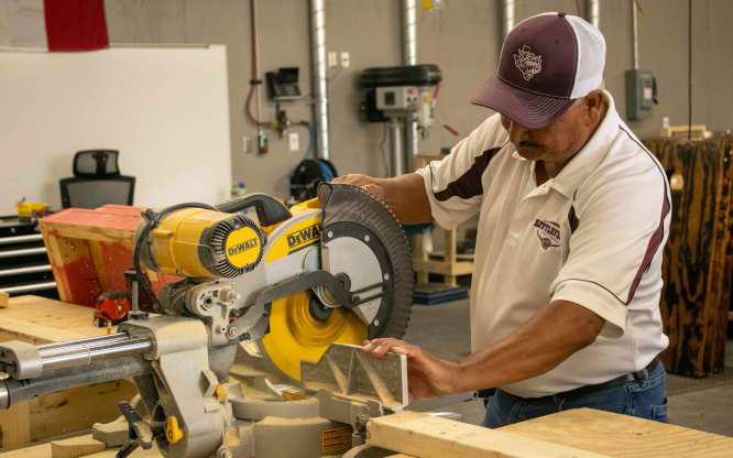Ray Vargas uses a miter saw to make a cut in his woodworking class at Littlefield High School. (Staff Photo by Madison Vidales)