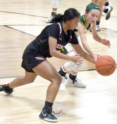 TIGHT DEFENSE – Springlake-Earth sophomore, Taytum Goodman (5), gets her hand on the ball, as she goes for a steal on the defensive end of the floor, during the second half of the Lady Wolverine’s loss to the Lady Horns on Tuesday during their season-opener. (Staff photo by Derek Lopez)