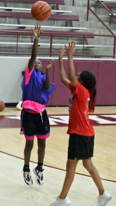 GETTING TO THE BASKET – A Littlefield summer camper gets to the basket and puts up a floater over the defense, during a pick-up game at the afternoon session of the Littlefield Girl’s Summer Basketball Camp on Tuesday at Wildcat Gym. (Staff Photo by Derek Lopez)