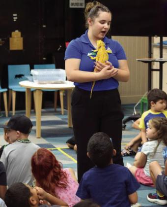 Children watch as STEM educator Mac Richard from the Lubbock Science Spectrum shows off a bearded dragon during an educational program at the Lamb County Library on Wednesday, June 10.