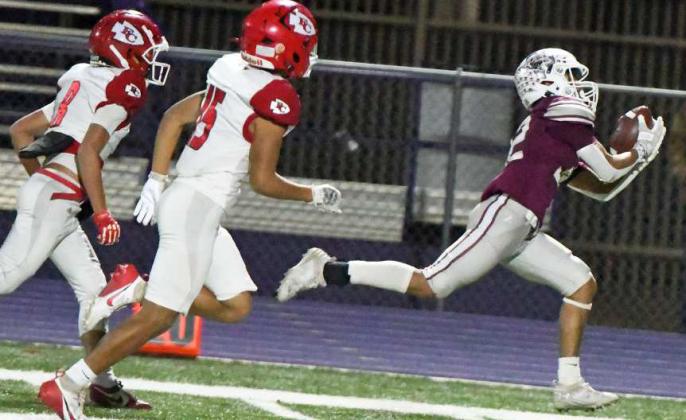 Littlefield senior receiver, Gabriel Villanueva, catches a pass in stride on the Friona sideline as he runs away from two Chief’s defenders on his way to a touchdown, during the Wildcat’s Bi-district victory over Friona in Clovis, N.M. on Friday in the Class 3A Football Play-offs. (Staff Photo by Derek Lopez)