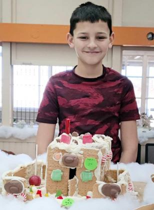 JOSHUA BOWNDS won third place in the 8-11 age division with his gingerbread house at the Lamb County Library’s contest. Taking first place was Riley Patterson, and second place was won by Arian MacDonald. (Submitted Photo)