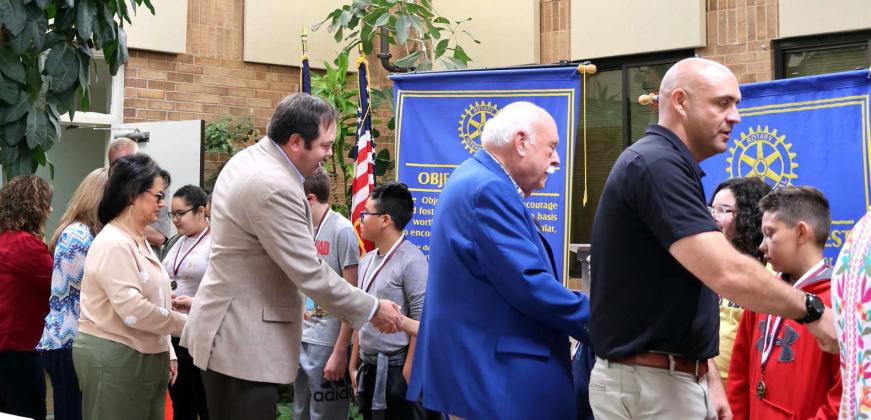 Following the presentation of the Readers, Writers, and Reasoners Award presentation on Thursday April 25, 2024 at the atrium of Lamb Healthcare Center, each Rotarian congratulates the students. It is a long held tradition. (Photo by Ann Reagan)
