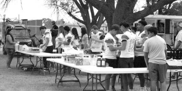 Members of the Springlake-Earth ISD football team prepare burgers and hot dogs as part of a fundraiser for the Springlake Volunteer Fire Department.
